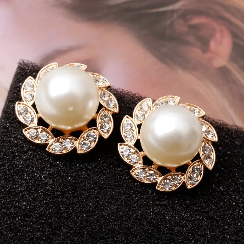 Elegantes pendientes de perlas y hojas brillantes