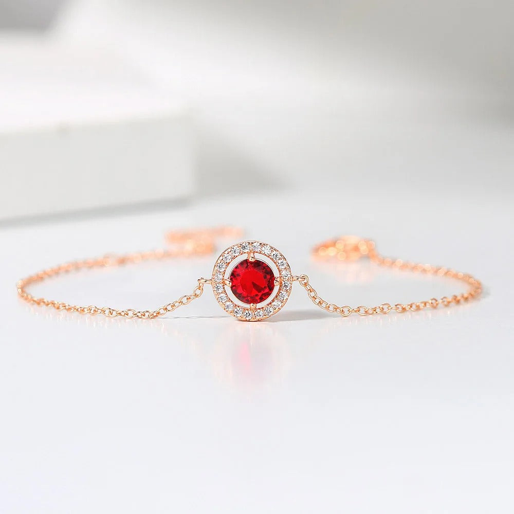 Pulsera clásica de oro rosa con gemas rojas redondas y cristales