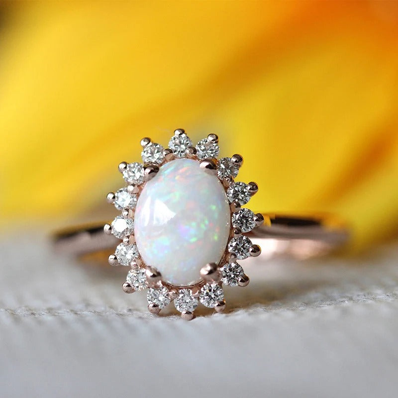 Bague vintage ovale en or rose avec opale et bordure en cristal rayonnant