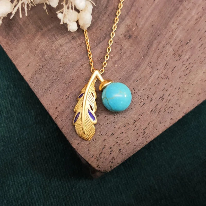 Collier vintage avec pendentif plume, perle turquoise dorée et perle.