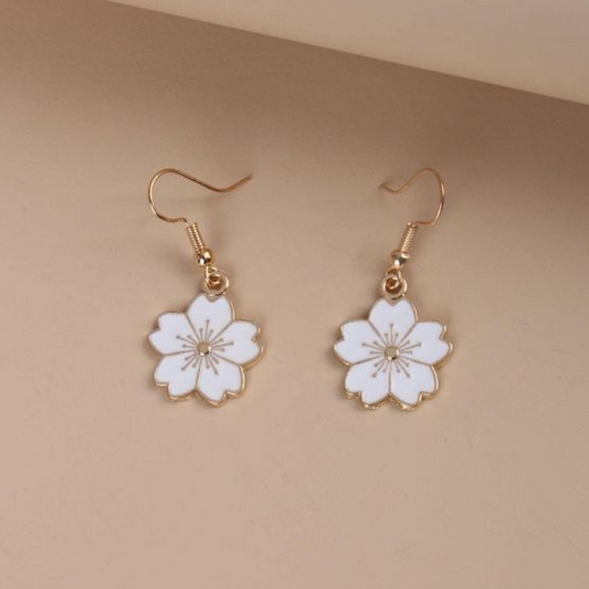 Elegantes pendientes dorados con flores blancas